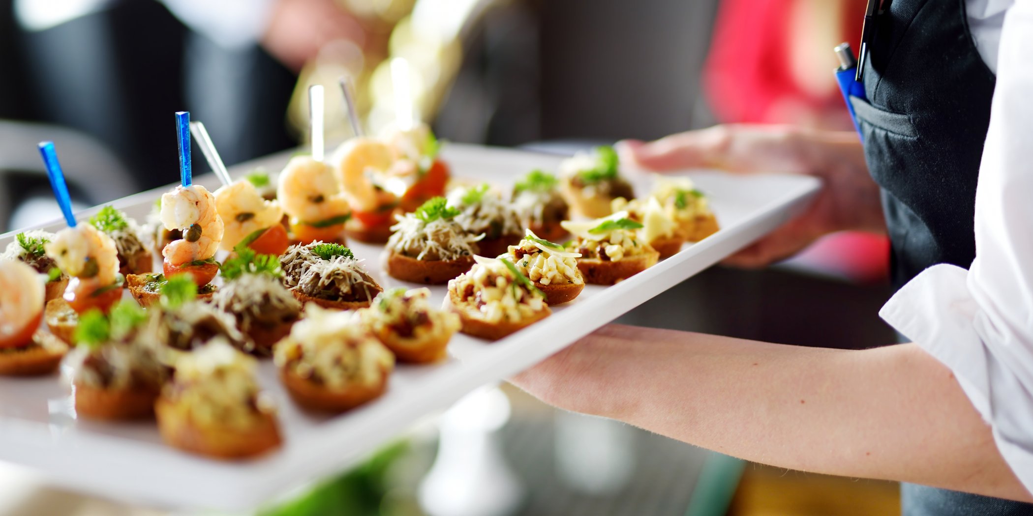 Close-up of a tray held by waitress containing beautifully presented entrés