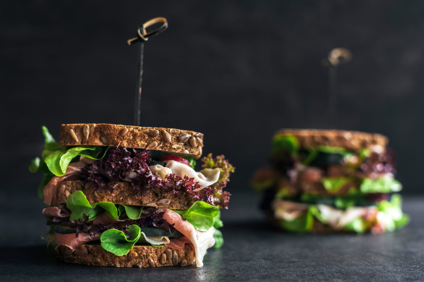 Gourmet sandwiches, prawn and whole grain bread on a dark graphite worktop