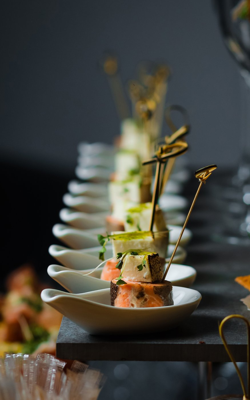 White fish and salmon steaks stacked and beautifully presented in a row of bowls