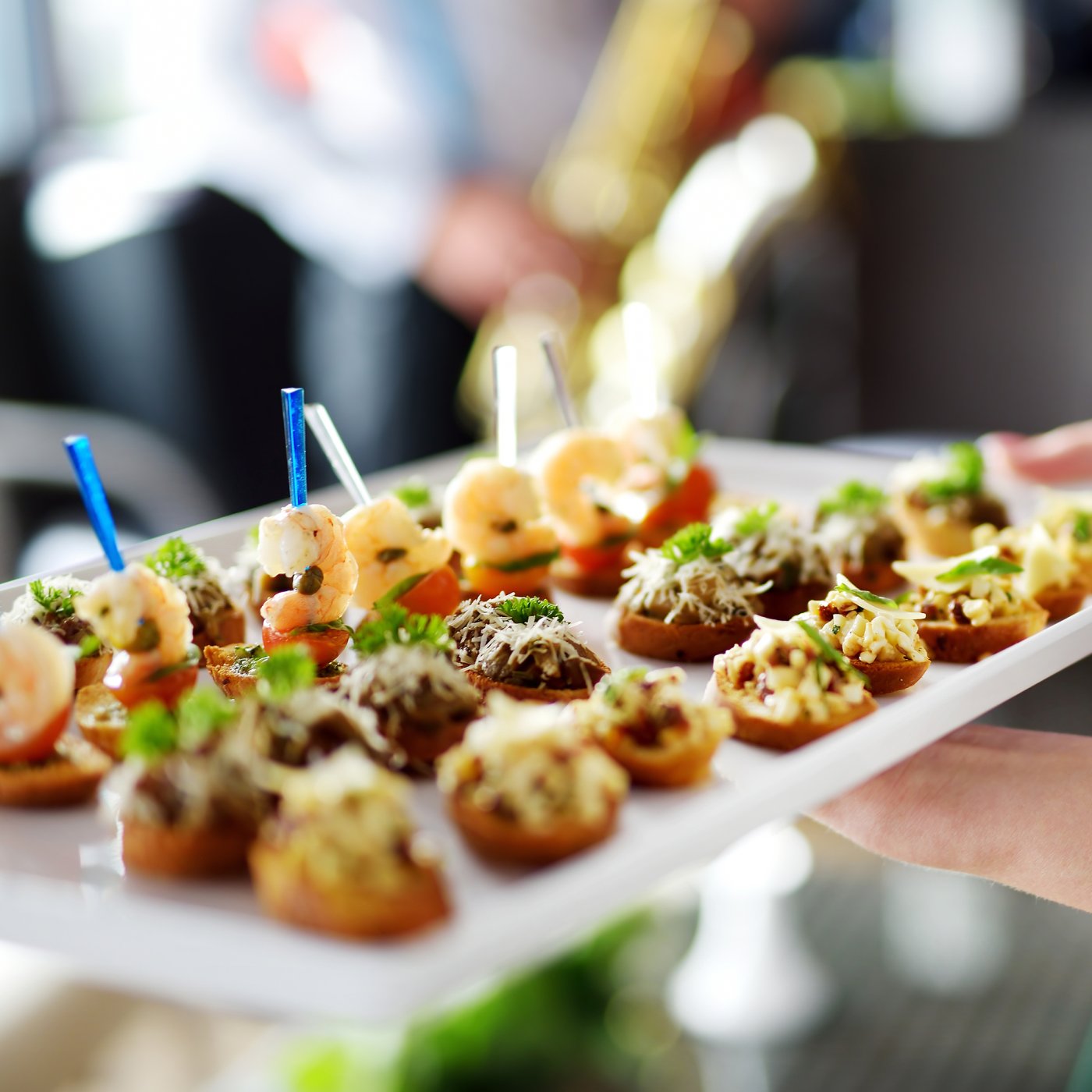 Close-up of a tray held by waitress containing beautifully presented entrés