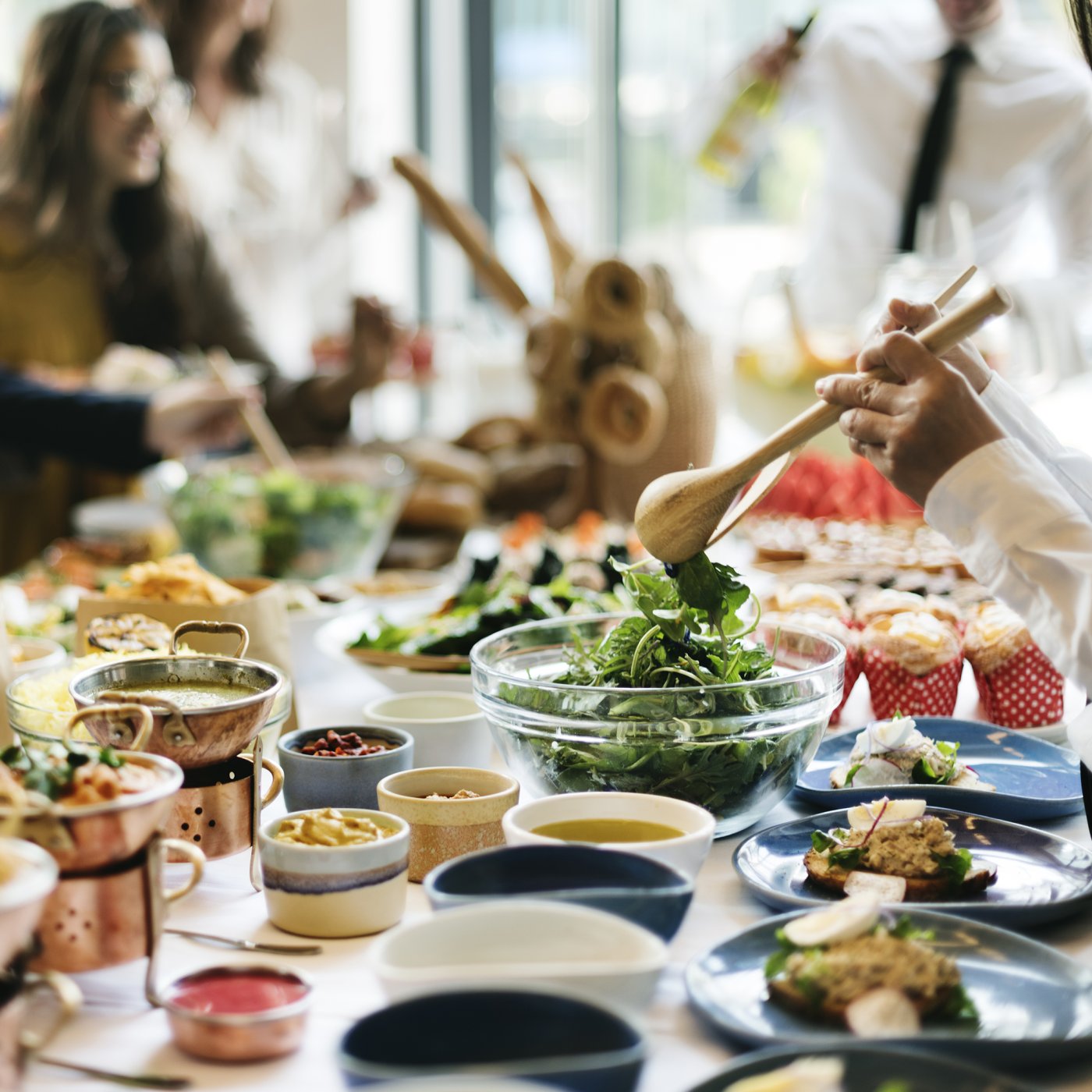 View across a dining table in a sociable setting with various curry and meat dishes beautifully presented