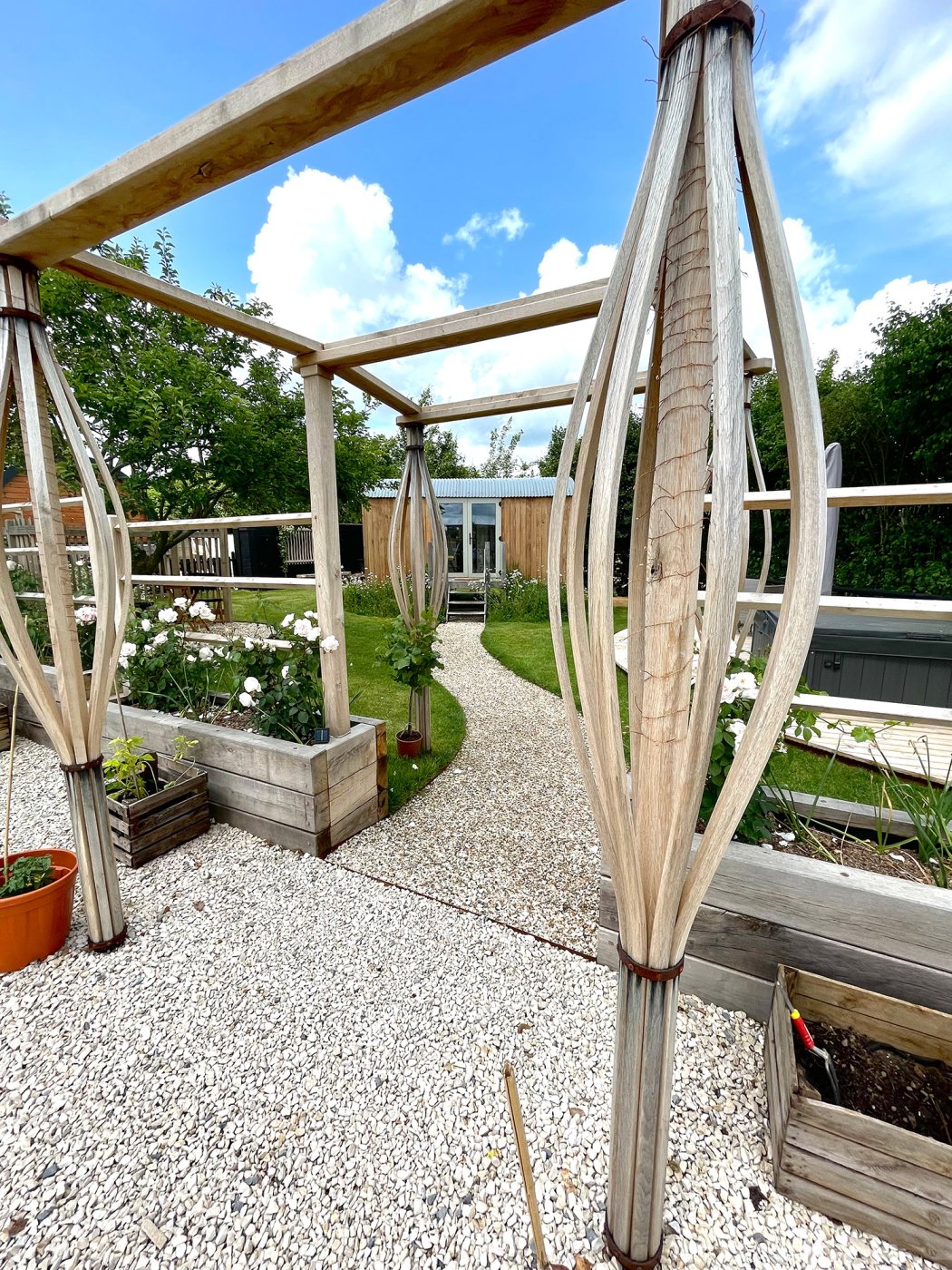 External view of the Shepherds Hut looking through pergola and raised planters