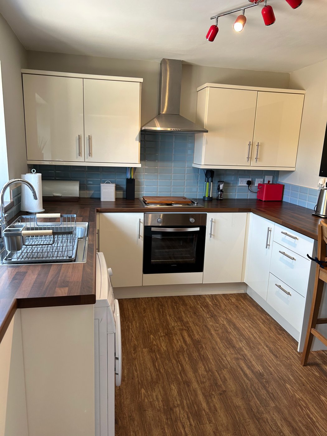 Modern kitchen with dark wood worktops and gloss cream cupboard fronts