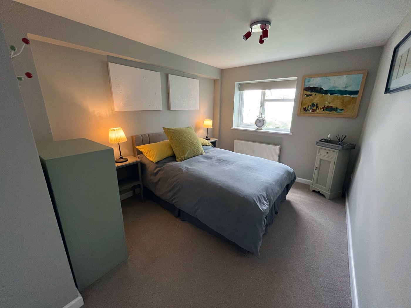 Interior shot, bedroom of the Stables Ground Floor, purple bedding on double bed, yellow cushion, spacious room